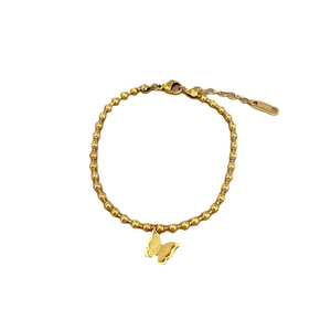 Gold beaded stainless steel bracelet with delicate butterfly charm on white background