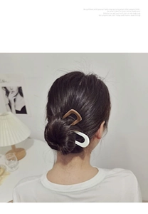 U-shaped hair pins in beige and light brown shown on model for bun hair styling
