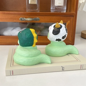 Vue arrière de figurines de dragon et vache en résine sculptée sur un livre