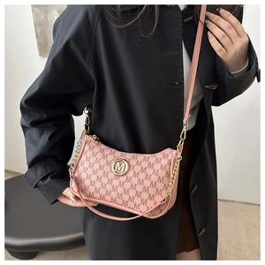 Detail of pink monogram underarm bag with metal M logo and mixed chain strap on model
