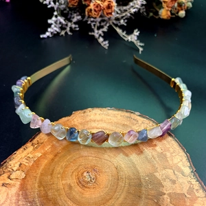 Detailed macro view of handmade colorful raw crystal stones wired onto a gold crown headband