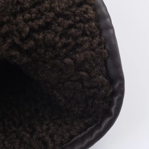 Detail of dark brown faux suede jacket lining featuring soft plush faux fur texture