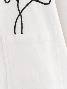 Macro view of white twill fabric texture with black linear embroidery and pocket detail
