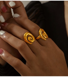 Close-up of elegant gold spiral twisted rings worn on fingers with a polished finish
