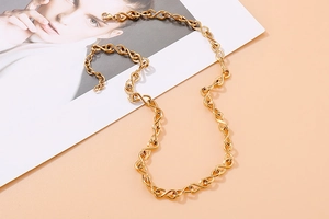 Dettaglio della collana a catena dorata con maglie a S in acciaio inox e chiusura a moschettone