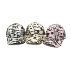 Close-up of three graffiti-print baseball caps in silver, beige, and pink colors