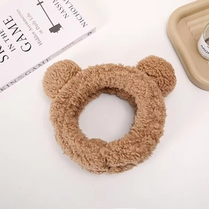 Detail of khaki plush headband with cute bear ears for skincare and makeup routines