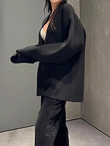 Détail d'un cardigan noir oversize à col en V avec une coupe décontractée pour l'hiver