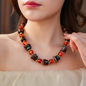 Close-up of irregular amber beads necklace with gold spacers on model's neck