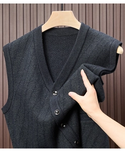 Detailaufnahme der dunkelgrauen Strickweste mit V-Ausschnitt, Textur und schwarzen Knöpfen