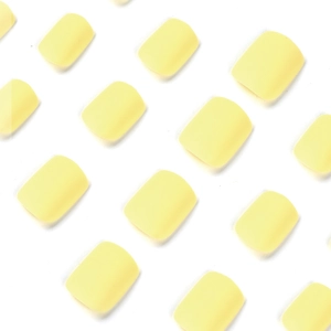 Faux ongles courts carrés jaune macaron mat disposés sur un fond blanc éclatant