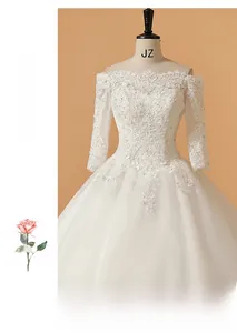 Détail de robe de mariée blanche à épaules dénudées avec broderie et manches transparentes