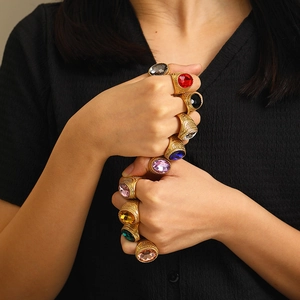 Detail of vintage gold plated rings featuring vibrant multi-colored oval cut gemstones