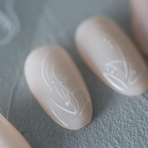 Minimalist nude pink long oval press-on nails with white abstract hand-painted lines