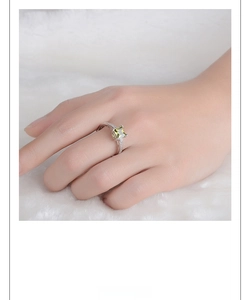 Detailed view of square lime green zircon ring with micro-pave setting on silver band