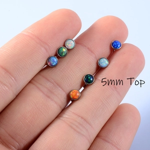 Detailed close-up of 5mm multi-color opal labret tops held in hand for size comparison
