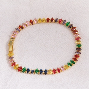 Macro detail of rainbow marquise-cut crystals and gold-plated fold-over clasp on tennis bracelet