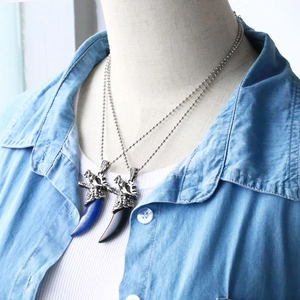 Dettaglio della collana con testa di drago e cristallo blu e nero su catena a sfere