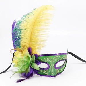 Classic Mardi Gras masquerade mask with green purple and gold feathers on white background