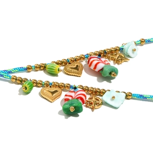 Détail du collier pendentif sucette coloré avec corde tressée bleue et perles d'or