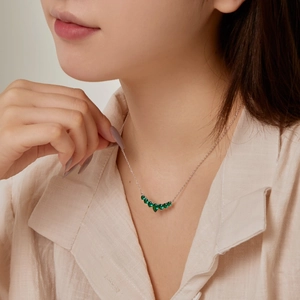 On-model view of S925 silver necklace with seven green heart-shaped cubic zirconia stones