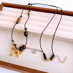 Détail du pendentif cheval vintage avec perles en bois œil de tigre et cordon ajustable