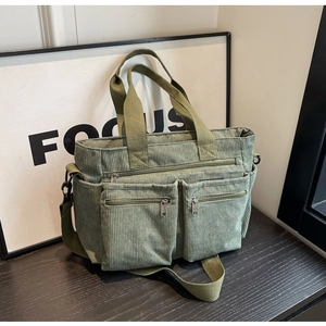 Olive green corduroy tote bag with multiple zip pockets and adjustable shoulder strap