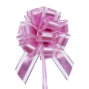 Detail of pink matte pull bow ribbon with metallic stripes for gift wrapping