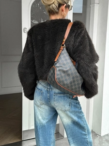 Street style shot of a crossbody bag with classic monogram pattern and brown leather strap