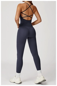 Détail du design dos croisé sur une combinaison de yoga bleu marine avec sangles géométriques