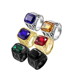 Macro detail of men's rings with large square stones in silver, gold, and black finishes