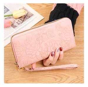 Detailed close-up of pink long wallet with 3D embossed rose pattern and wrist strap