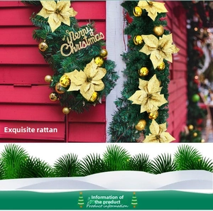 Détail de guirlande de sapin avec fleurs de poinsettia dorées et boules de noël