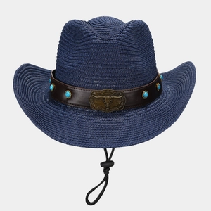 Detail of western straw hat featuring turquoise studs and a vintage bull head buckle