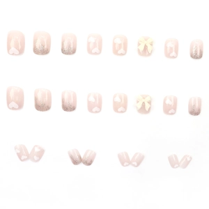 Sweet pink press-on nails set featuring white hearts and 3D bows with silver glitter finish