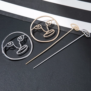 Close-up of gold and silver hollow face hair sticks with artistic minimalist design