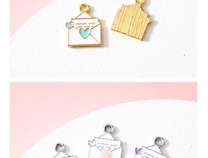 Detail view of heart envelope charms in gold and silver alloy for jewelry making