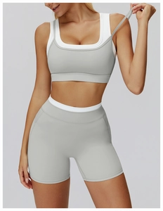 Detail of high-waist sports shorts and layered bra in light grey green yoga set