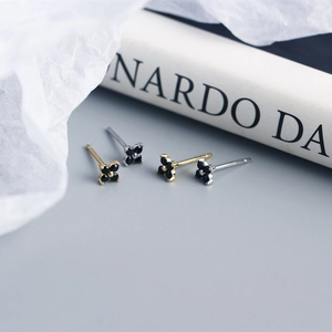 Detail shot of dainty gold and silver S925 floral earrings with black petals and diamonds