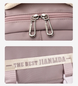 Detail of durable dual metal zippers and purple nylon strap on a school backpack