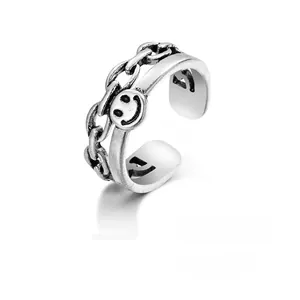 Detailed macro view of vintage silver alloy open ring with smiley face and chain texture