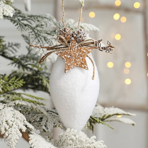 White droplet Christmas ornament with wooden star pinecone and hemp rope on snowy branch