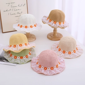 Group of colorful children's summer straw hats with elegant lace and daisy flower details