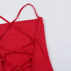 Detail of red backless dress showing adjustable criss-cross lace-up straps on fabric