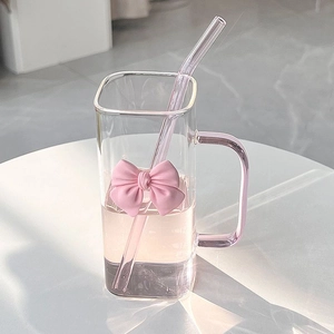 Detail of square glass mug featuring a pink 3D bow and matching glass straw