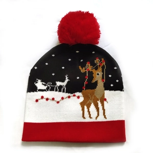 Detail of Christmas reindeer jacquard knit beanie with red pompom and snowflake pattern