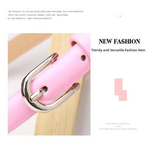 Close-up of pink slim belt with silver buckle wrapped on a wooden block