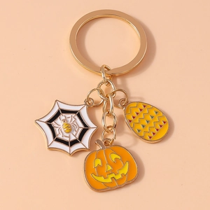 Detail of Halloween keychain featuring gold spider web, pumpkin lantern and colorful charms