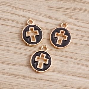 Close-up of golden alloy hollow cross coin pendants with black enamel oil drip finish