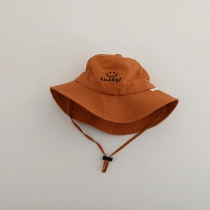 Detail of orange quick-dry sun hat featuring Lucky smiley face embroidery and chin strap